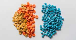Šarene granule sa veštačkim bojama pored prirodnih, bezbojnih granula, prikaz štetnih aditiva u hrani.